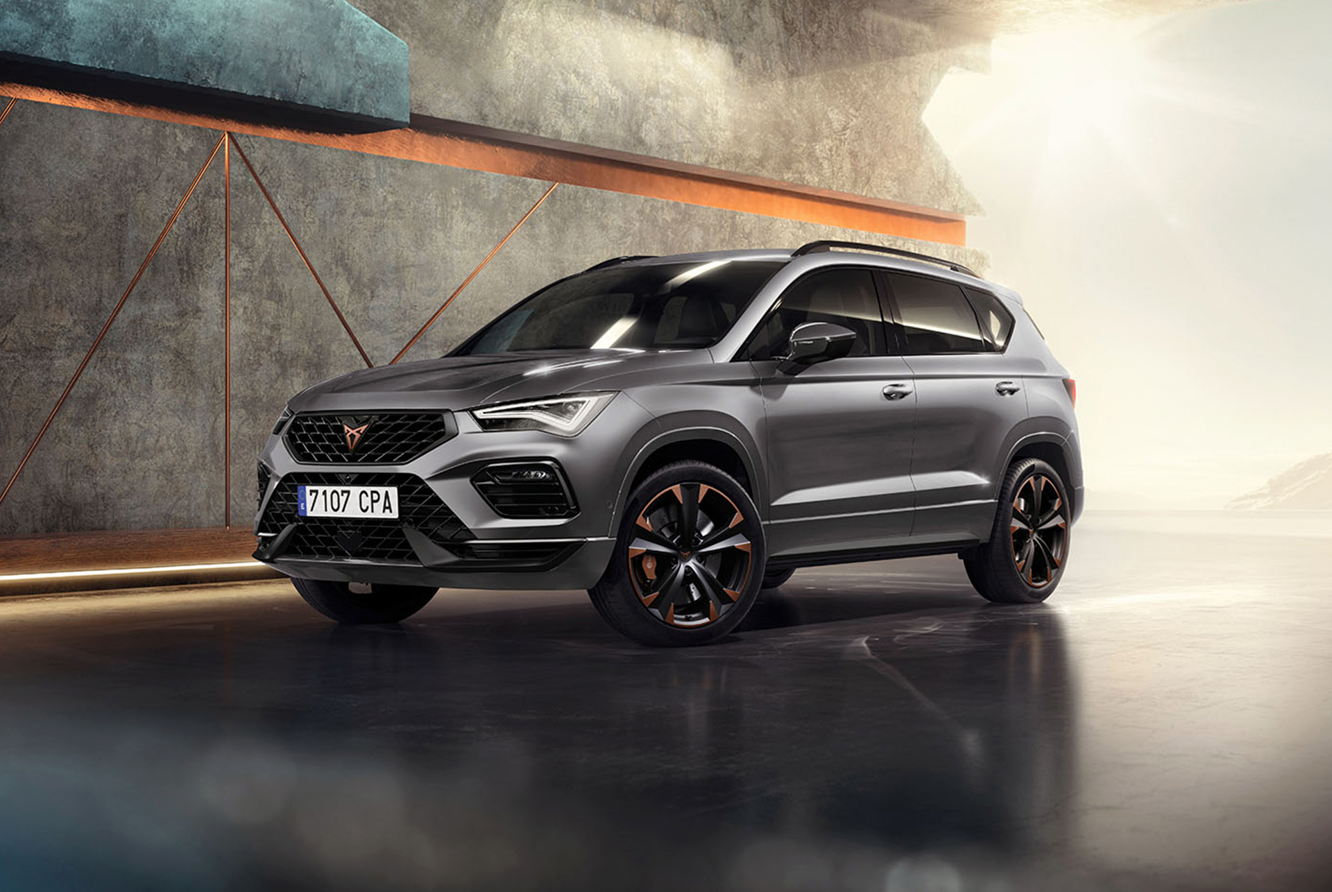 En 2024 cupra ateca i grafitgrått parkerad i en modern, industriell miljö.